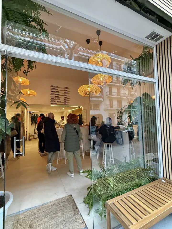 La entrada de HOROSCOFFEE en el Carrer del Rosselló, con clientes en la barra